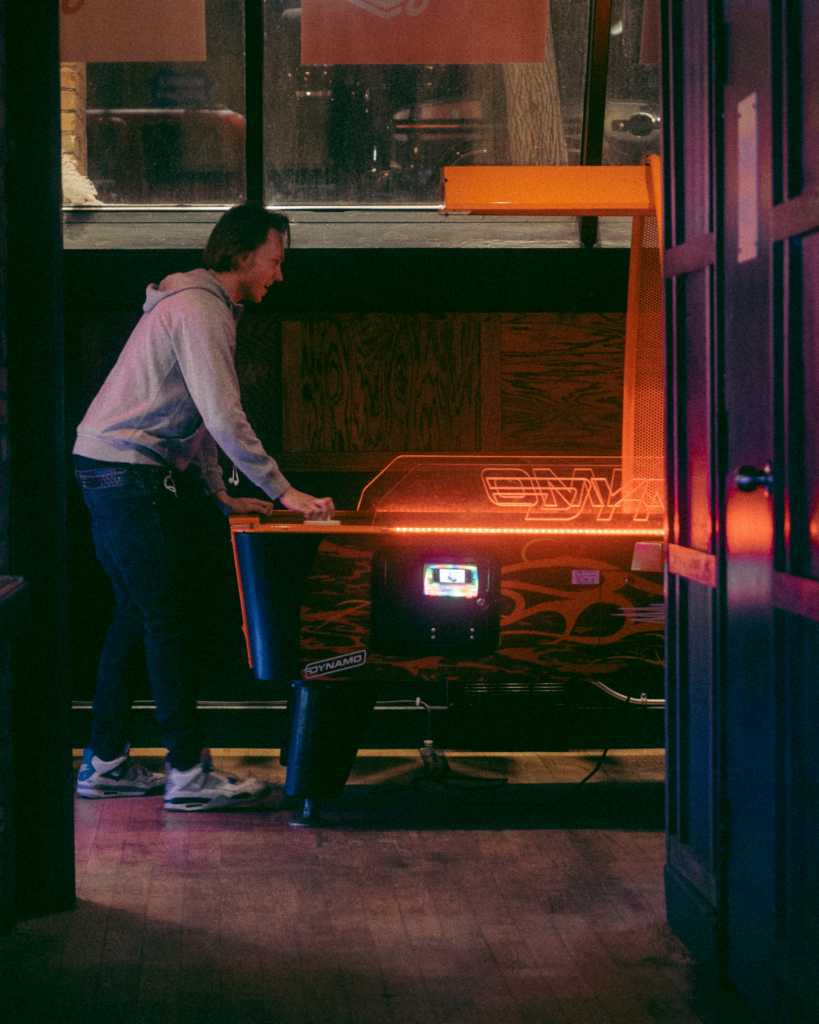 Guests playing arcade games and enjoying the entertainment at Greta arcade bar