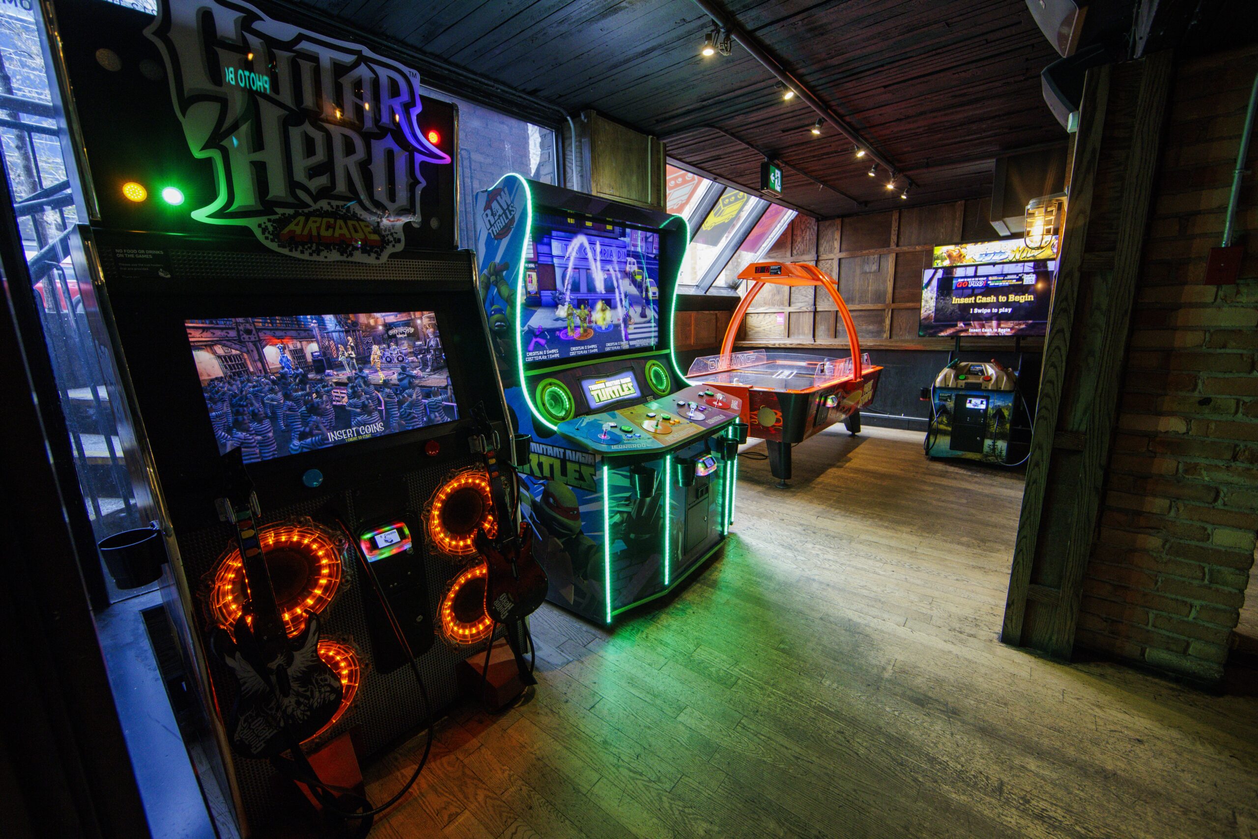 Guests playing arcade games and enjoying the entertainment at Greta arcade bar