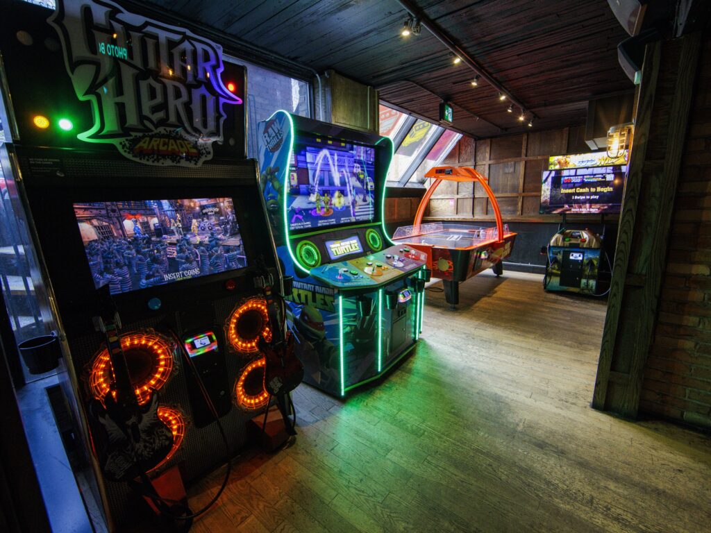 Guests playing arcade games and enjoying the entertainment at Greta arcade bar