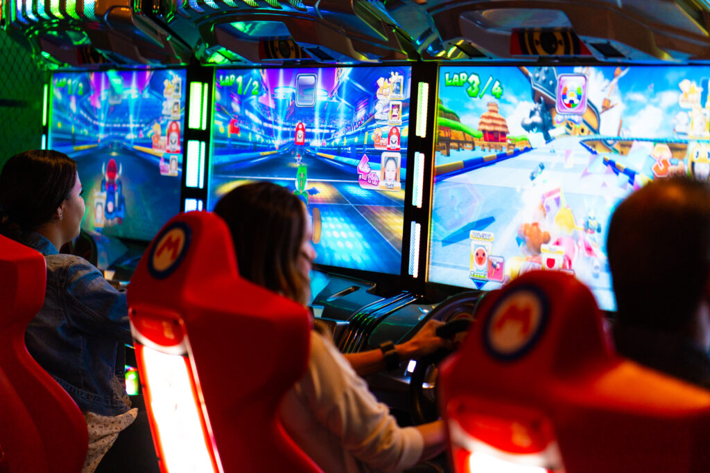 Guests playing arcade games and enjoying the entertainment at Greta arcade bar